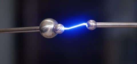 Electrostatic discharge spark between metal spheres, illustrating ESD hazards in industrial settings