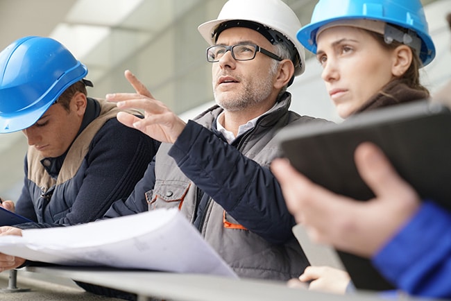 Engineers discussing reports and charts for process safety consulting at Sigma-HSE